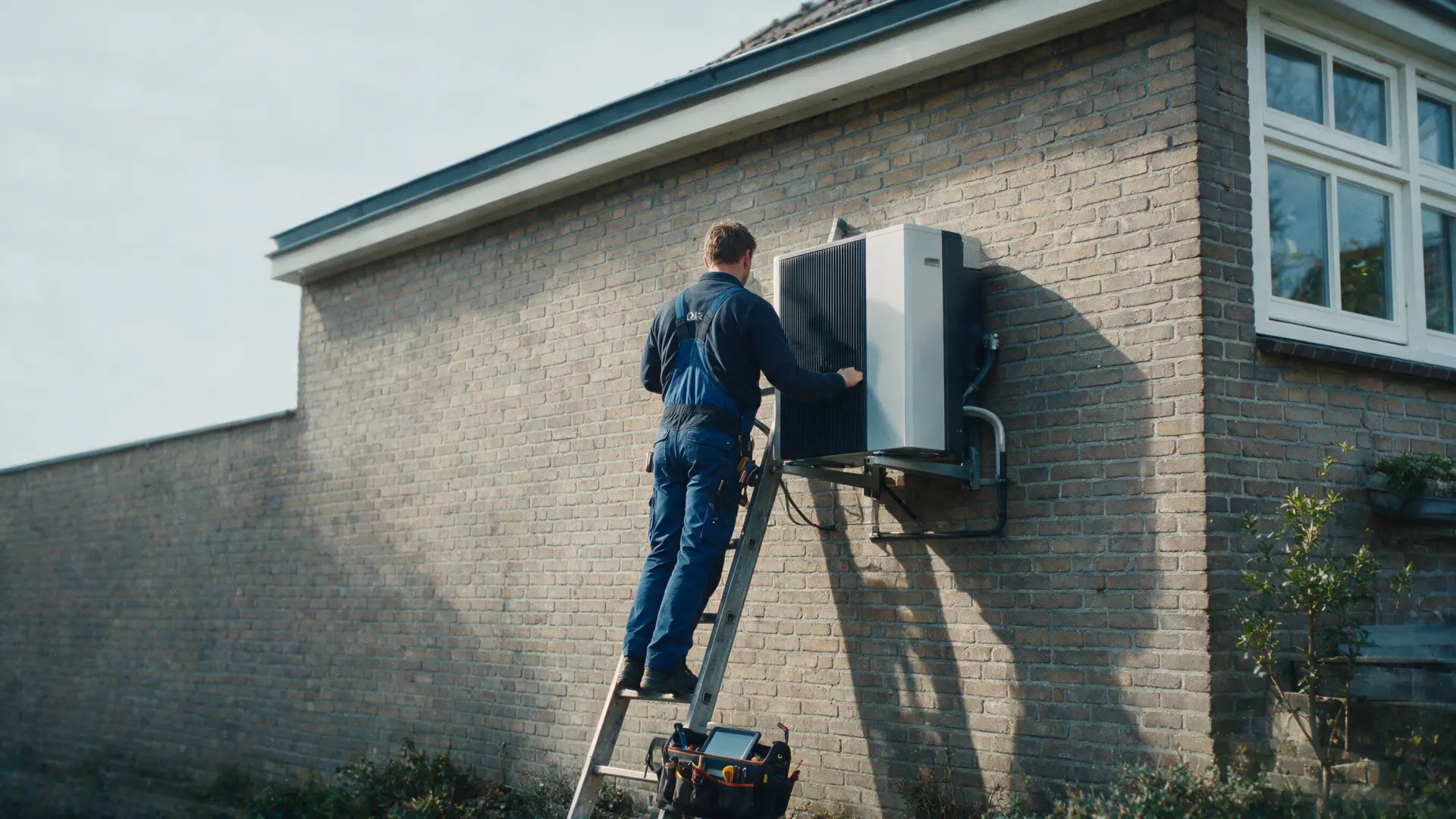 Installateur monteert een warmtepomp op een woning